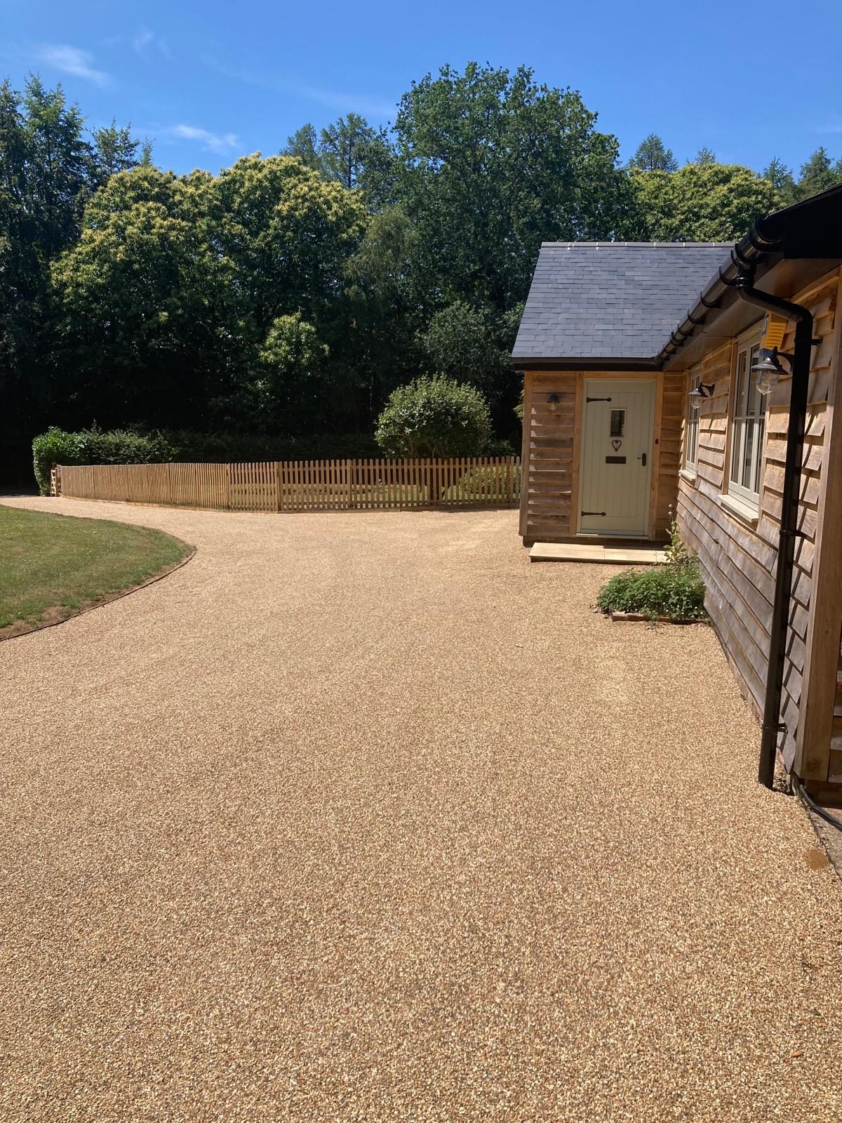 Golden tar and chip driveway beside a timber-clad house